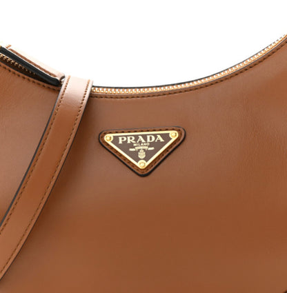 PRADA 
Soft Calfskin Arque Shoulder Bag Cognac